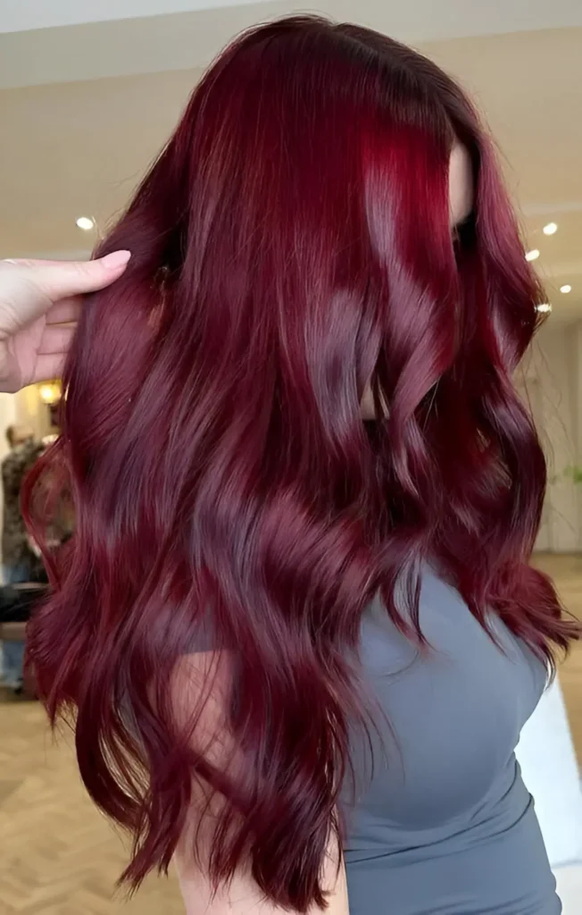 Woman with long, glossy, burgundy hair styled in loose waves.