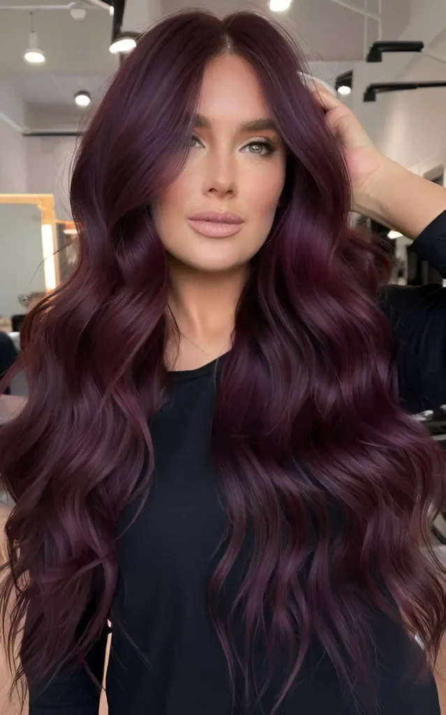 Woman with long, deep mahogany burgundy hair styled in subtle, flowing waves.