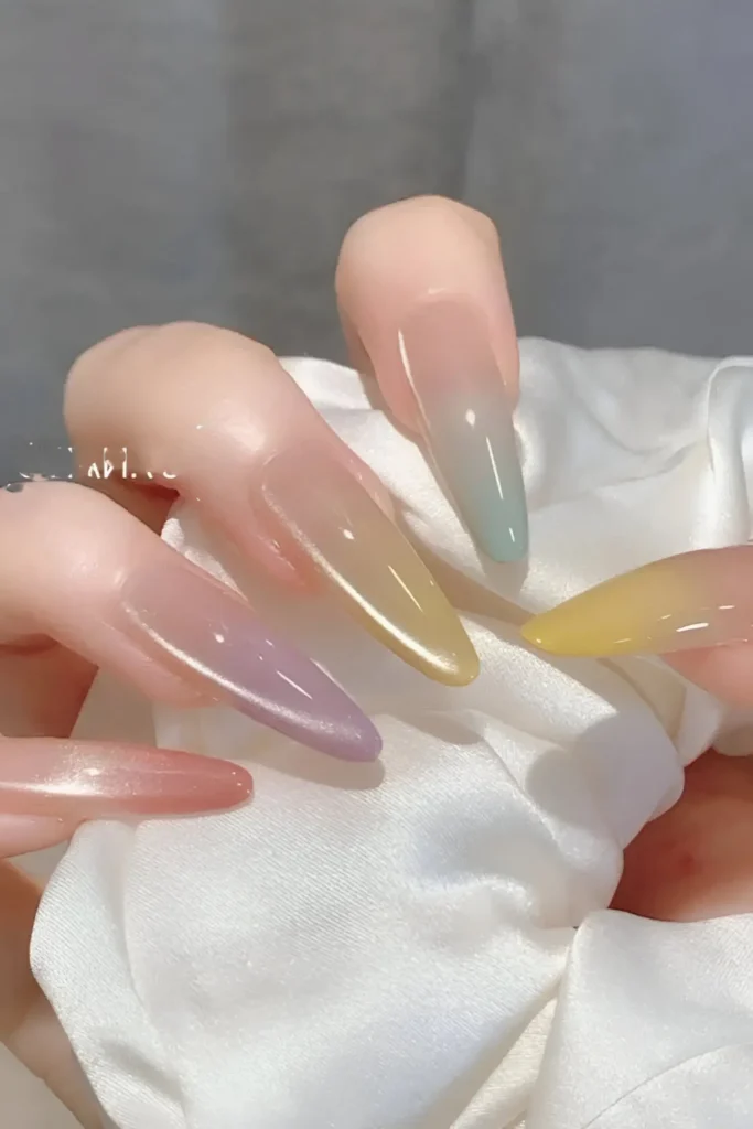 Cute nail design on long almond nails with sheer base blending into translucent pastel jelly tips (pink, lilac, green, blue, yellow) via vertical gradient/ombre.