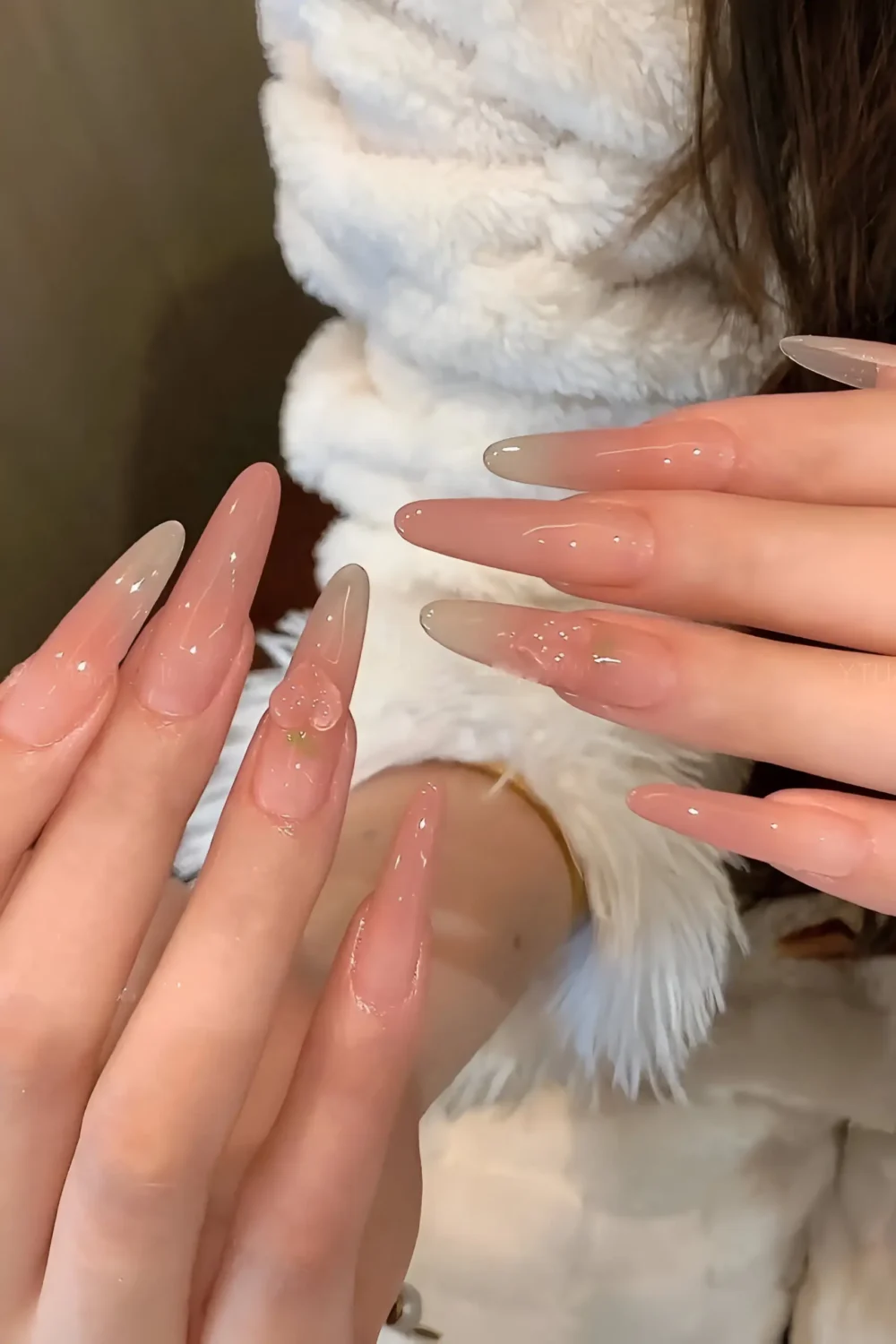 Cute long stiletto nails with minimalist sheer glossy nude finish and tiny subtle texture accent on one nail.