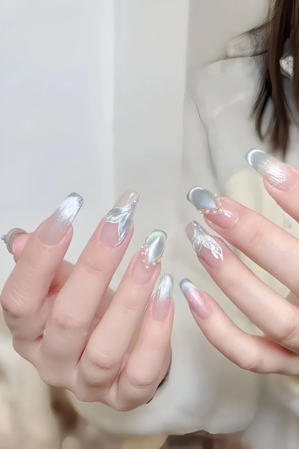 Cute long nails with grey cat-eye base, white sculpted accents, and pearl/crystal cluster details.