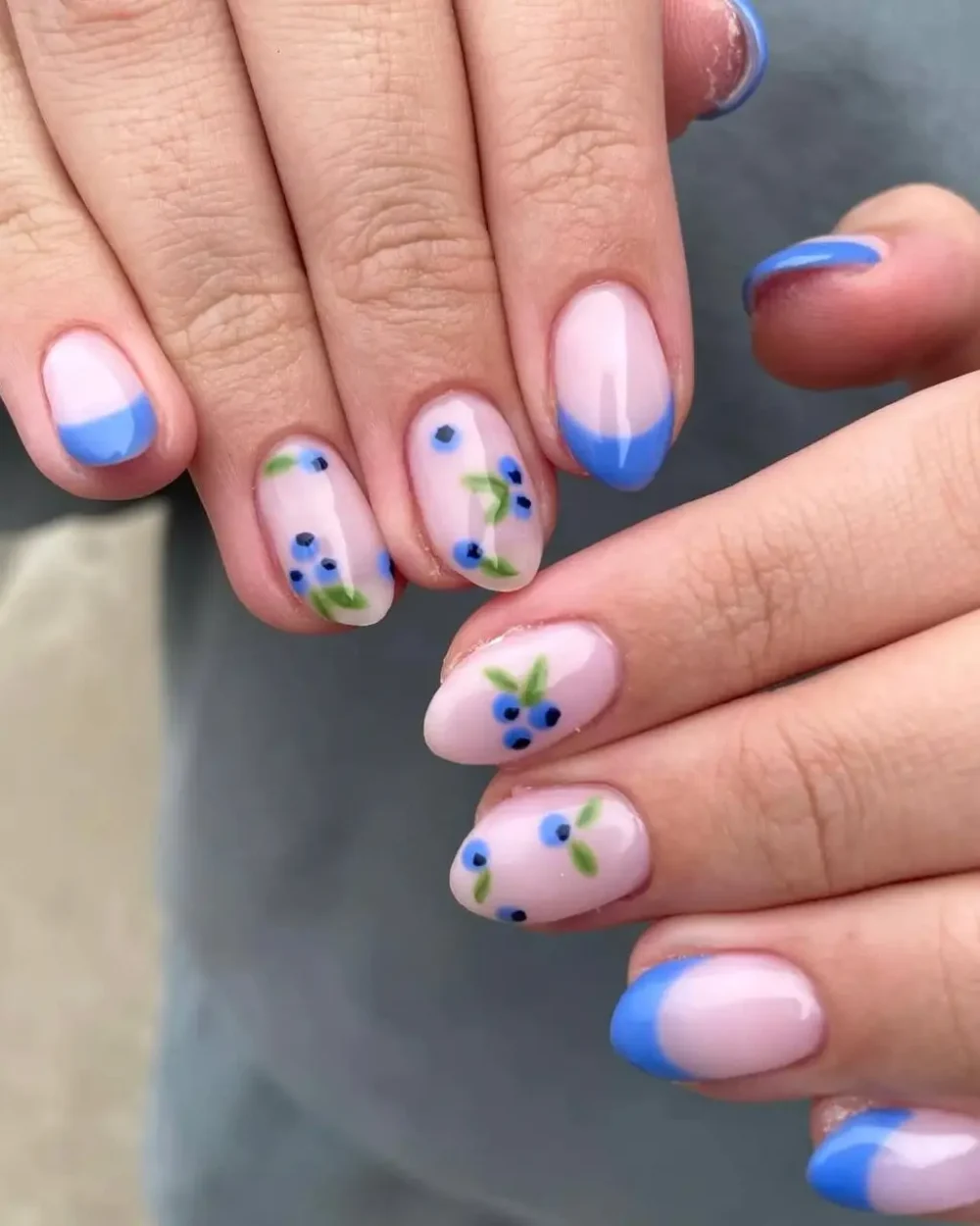 A sophisticated manicure featuring blueberry branch nail art paired with a bright blue French tip.